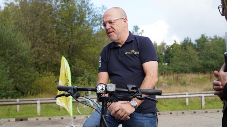 A business owner in Merthyr Tydfil sat on an e-bike at the launch event for the E-Move project in Merthyr Tydfil