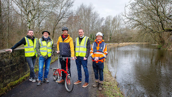 A small group of Walk Wheel Cycle Trust and Scottish Canals staff pose with members of the local community on the Monkland Canal towpath.