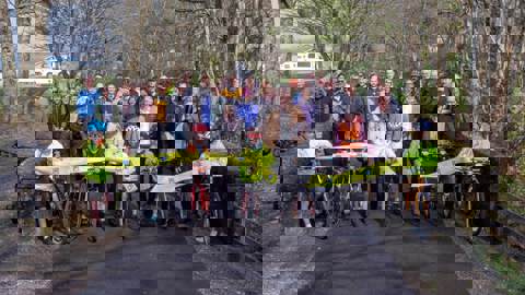 Group of people cutting the ribbon at opening of new walking and cycling path