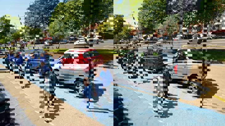 young children in uniform walking to school on a wide path, painted light blue