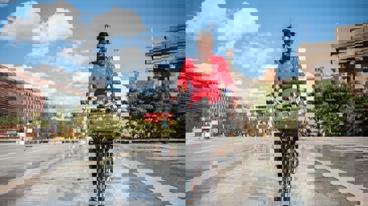 A women cycles through birmingham on a warm sunny day