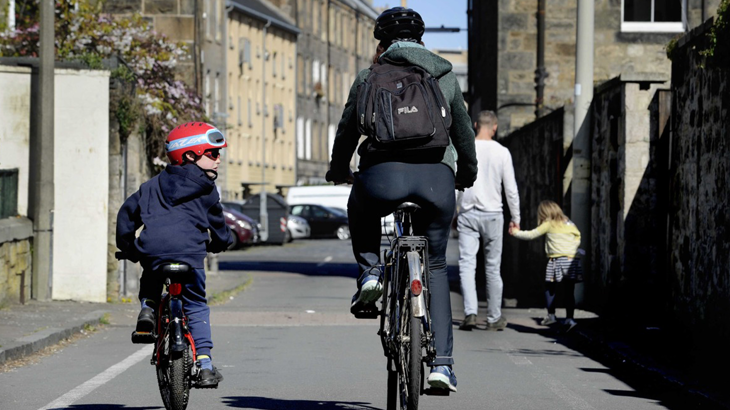 Two people cycling while socially distanced.