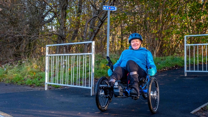 Jane pictured on her recumbent where a barrier had previously stopped her accessing the National Cycle Network.