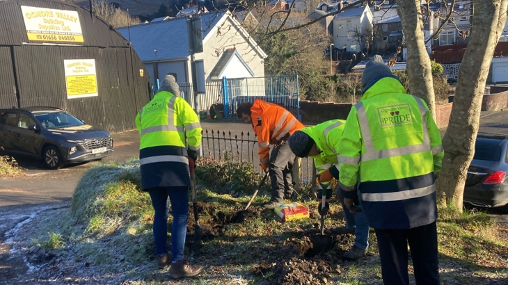Members of the Ogmore Valley Priide community group digging up earth in a residential area in preparation for installing benches along the Ogmore Valley cycle route.