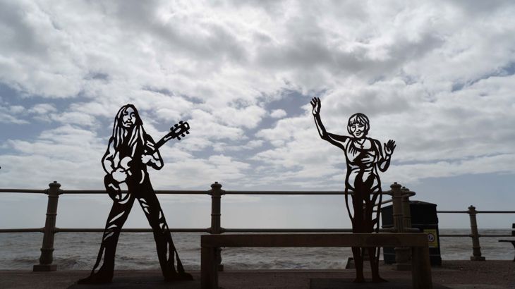 Portrait statues of Hastings heroes with sky and sea in the background