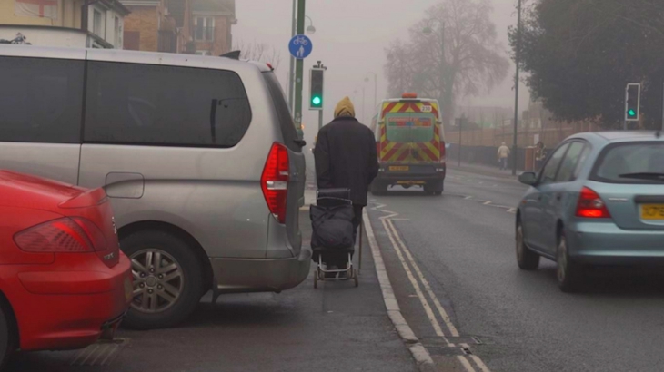 Walking Along An Obstructed Pavement With A Shopping Trolly And Walking Stick