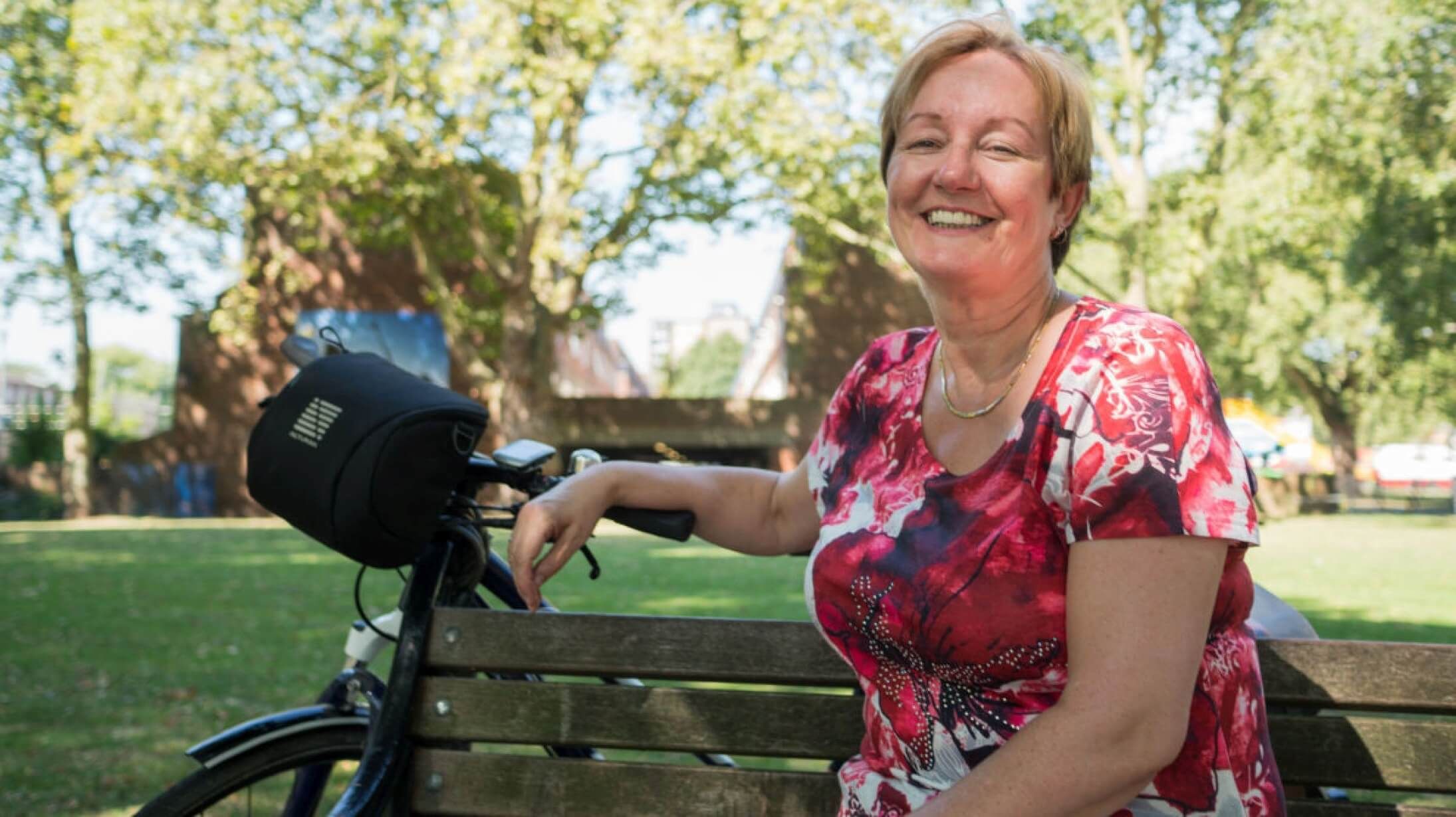 Woman sitting on bench with bike, in sunshine. ©2016, Jonathan Bewley, all rights reserved