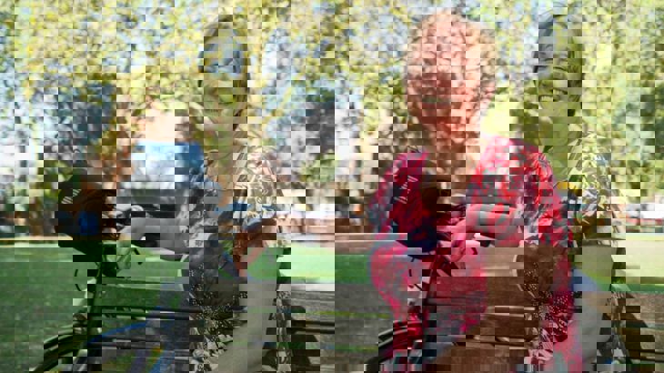 Woman sitting on bench with bike, in sunshine. ©2016, Jonathan Bewley, all rights reserved