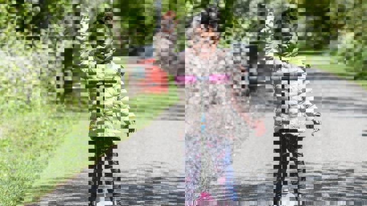 Girl with scooter on as traffic-free section of the National Cycle Network