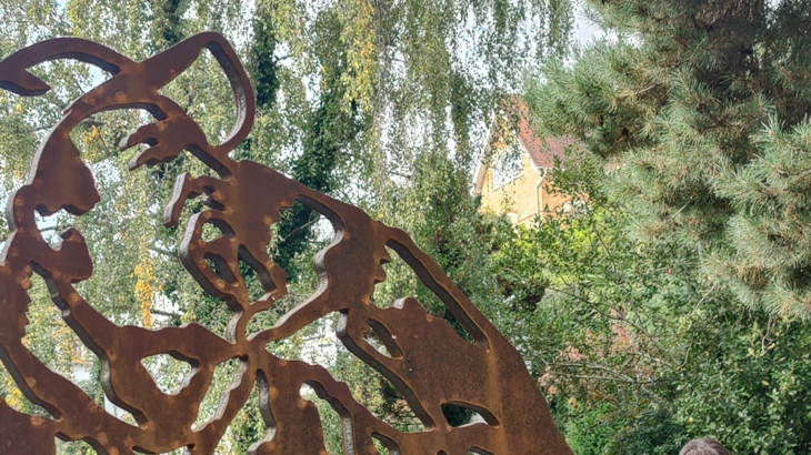 Close up of steel portrait of John Garard wearing a cap. Trees line the background.