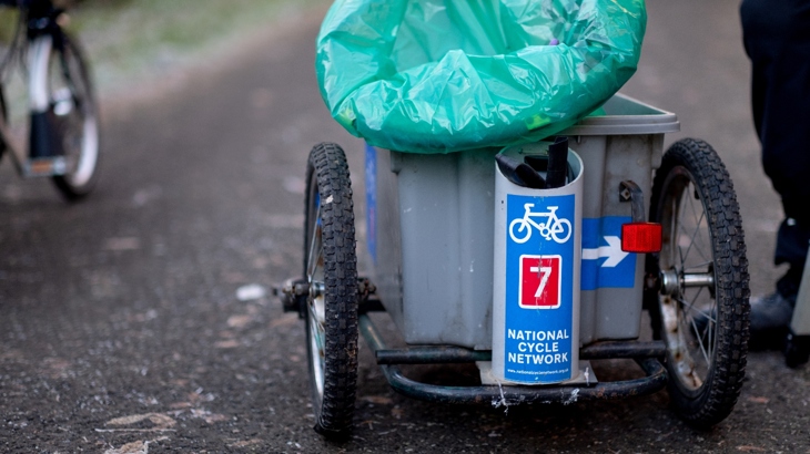 A handmade litter picking trailer attached to a Brompton, with the Thursday Squad volunteers in Renfrewshire.