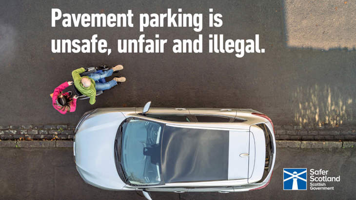 An adult pushing another adult in a wheelchair leaving a pavement and entering a road carriageway to get around a silver car parked along the footway.