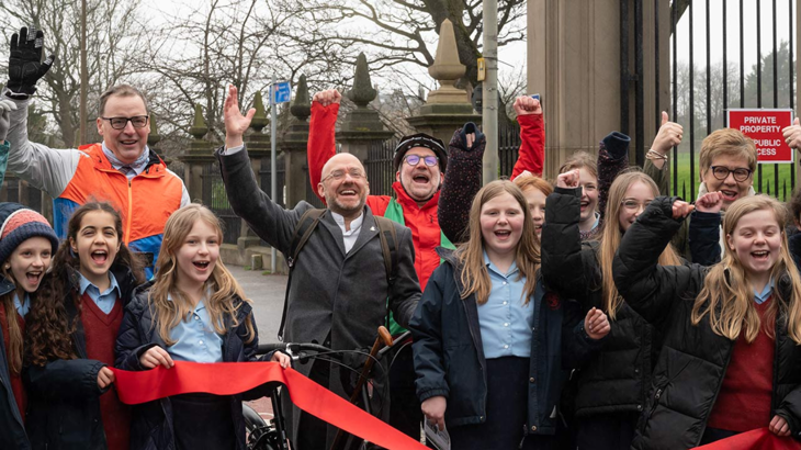 A group of children and politicians celebrating the opening of a new cycle route.