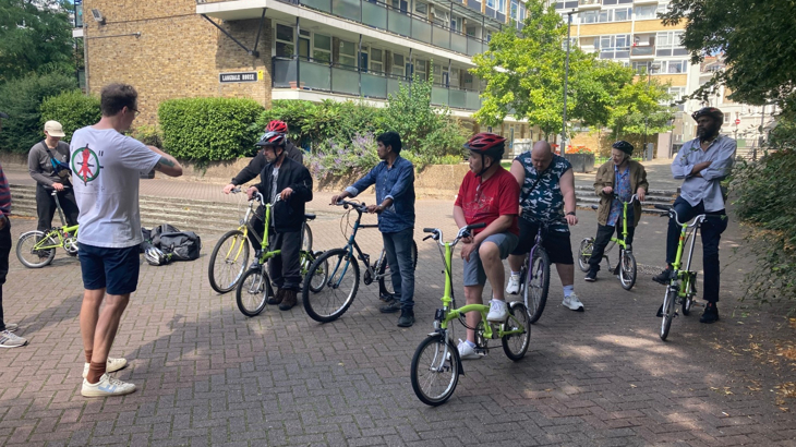 Walk Wheel Cycle Trust staff working with Riverside Hostels customers outdoors.