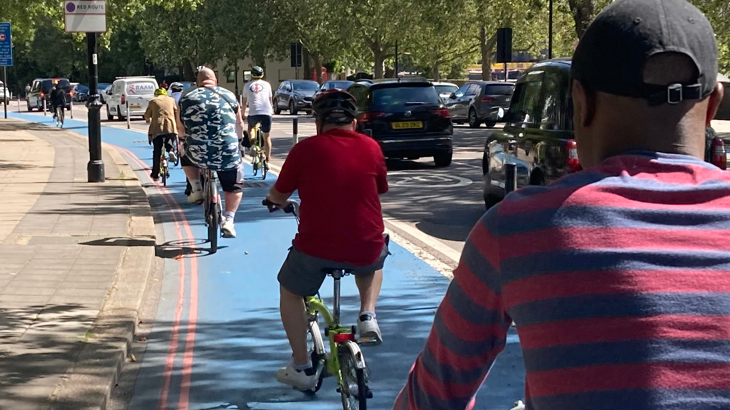 Riverside Hostel customers cycling in a line on a cycle path through London.