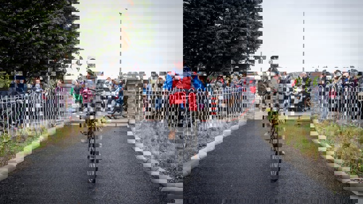 Elderly Male Cyclist With Crowd In Background