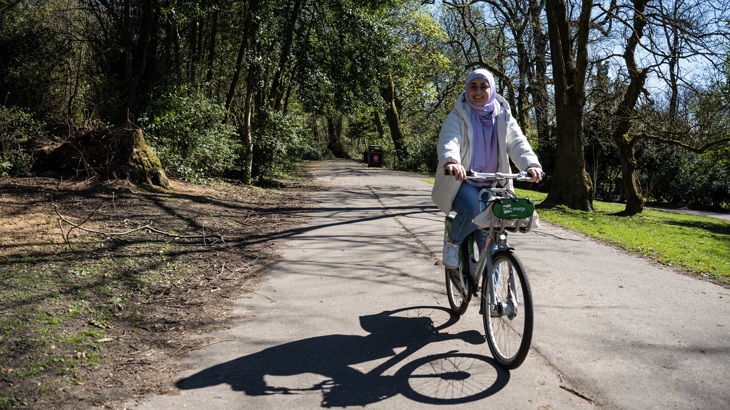 A person is shown cycling in a park.