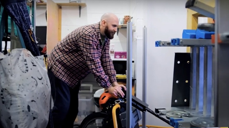 A man wheels a trolley through a warehouse.