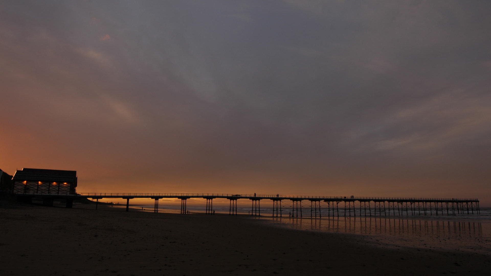 Sunset over beach and pier Saltburn