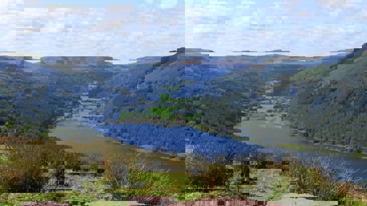 View of reservoir in Wales surrounded by mountains and trees