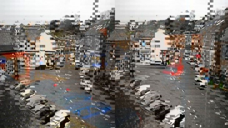 Town centre in Scottish town with many parked cars
