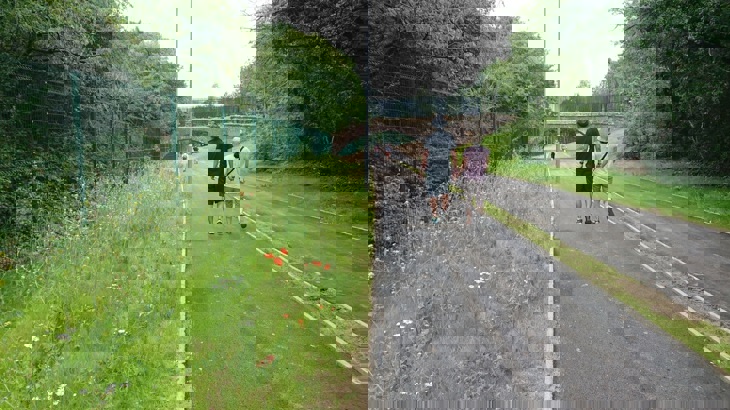 A picture of the Kingston and Merton path after work was completed, the bridge can be seen with a smooth tarmac trail running beneath it.