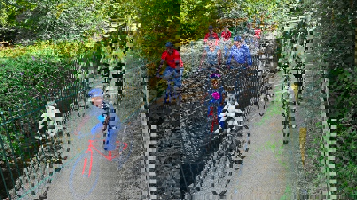 adults and children cycling on bridge