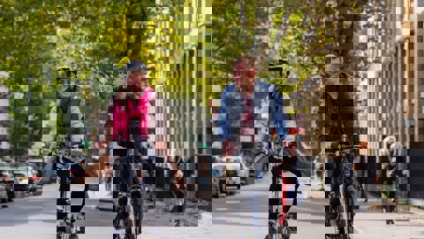 A man And A Woman Cycle On A London Road 