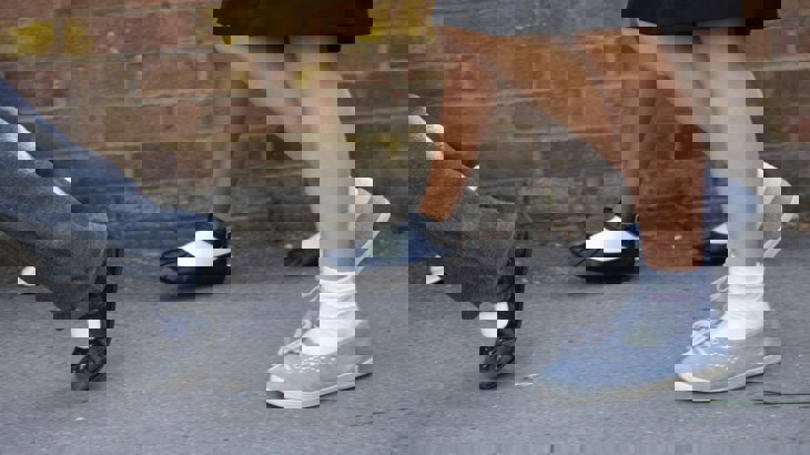 A close up photo of the legs of some school children walking to school