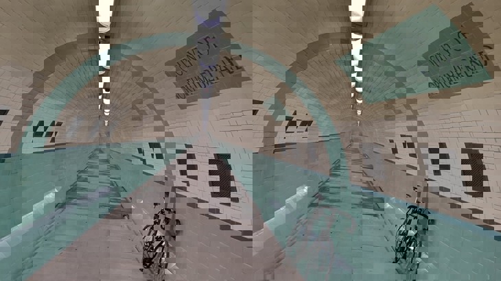 A bike rests against the blue and white tiled walls of the Tyne River foot tunnel 