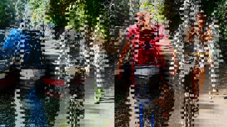 Woman cycling on canal towpath