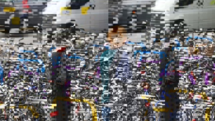 A Woman Unlocking Her Bike At A Bike Parking Stations In Oxford 