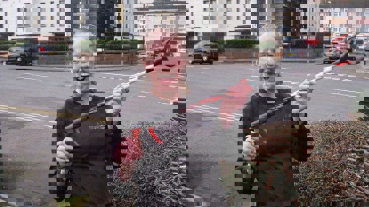 Person in running kit brandishing litter picking tool