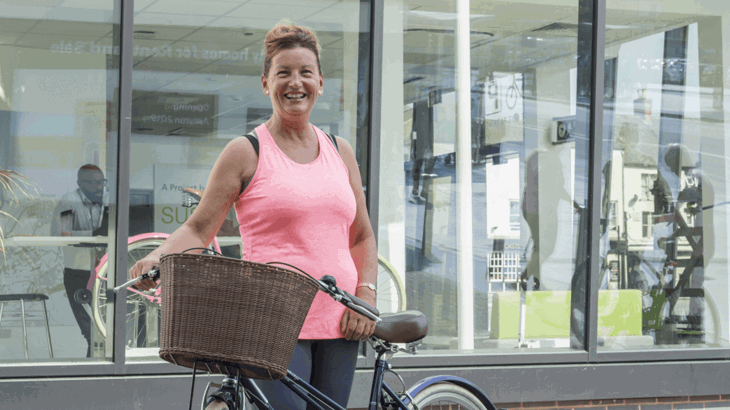 A photo of Debra Corkain smiling with her bike 