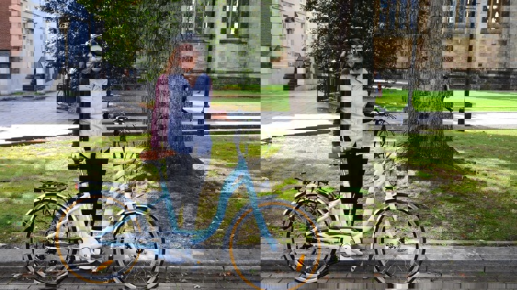 A woman poses with an e-bike 