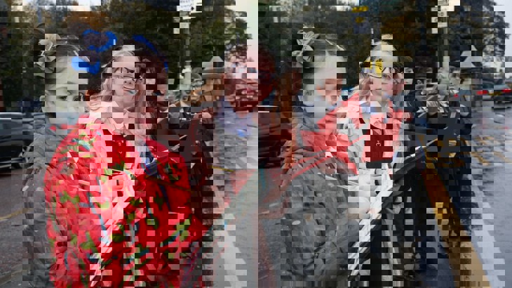 Children observing traffic and taking notes outside of school