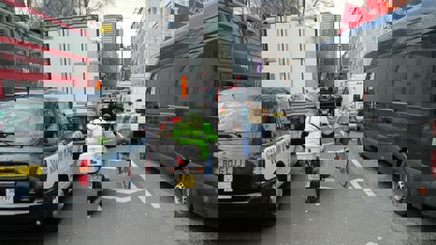 A person on a bicycle tries to navigate through congestion in London
