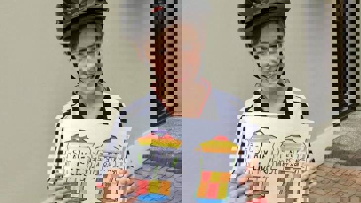 Conan Shivers from St Mary's Primary School holding his cycling jersey design that has saves lives on the front and keep your distance on the back and NHS on the sleeves