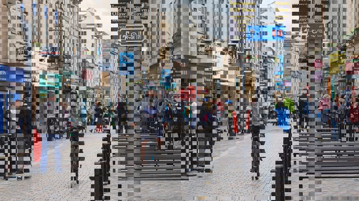 Man cycling down high street