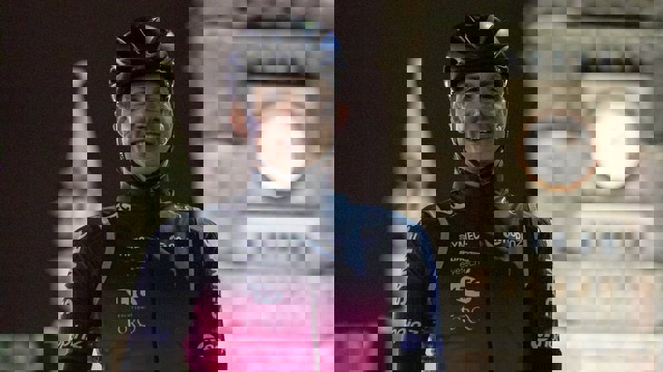 Tom standing with his bike and helmet at Bristol Temple Meads in the dark