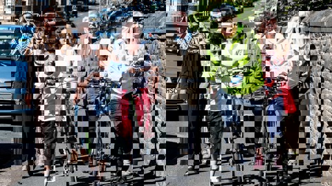 A group of people walking down the street together chatting and laughing