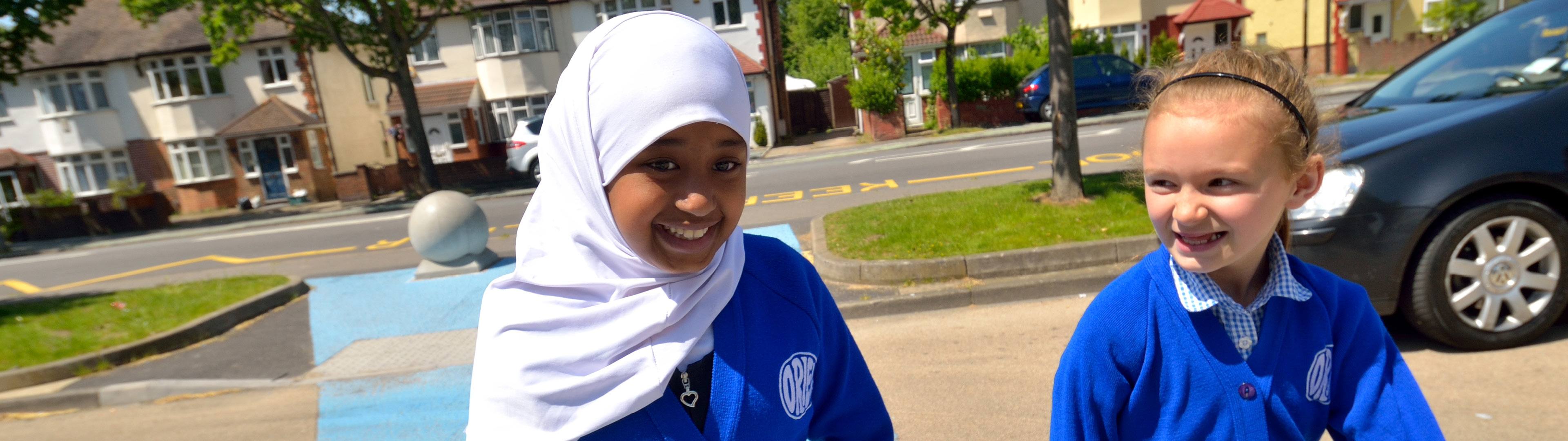 Two girls in blue uniforms walking to the school gate