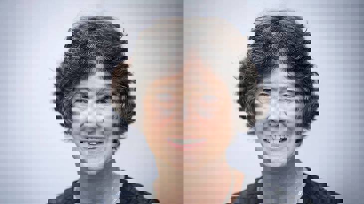 Head shot of Walk Wheel Cycle Trust Chair of Trustees, Lynne Berry, wearing a dark grey top in front of a pale grey background.