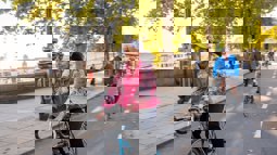 A girl cycles along a segregated cycle lane during the autumn time through Embankment in London, with other people cycling behind her in the background.