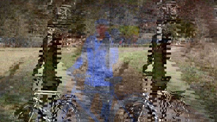 person holding oxford preservation trust award plaque and bike on traffic free shared path