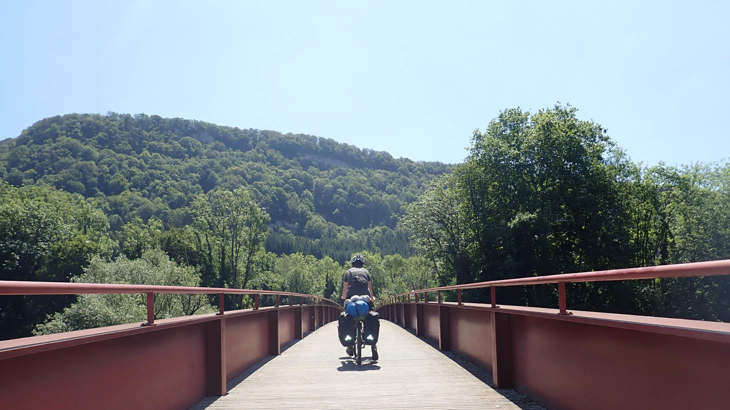 Photo of Lilith cycling off into the distance on the couple's cycle touring trip.