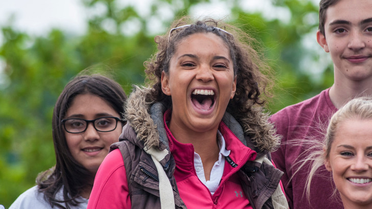 Close-up photo of a group of teenagers laughing and smiling at the camera.