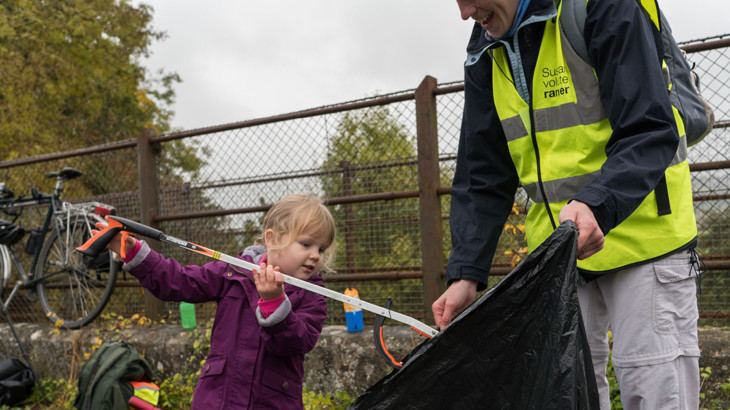 Mum and daughter picking up litter on a traffic-free National Cycle Network route.