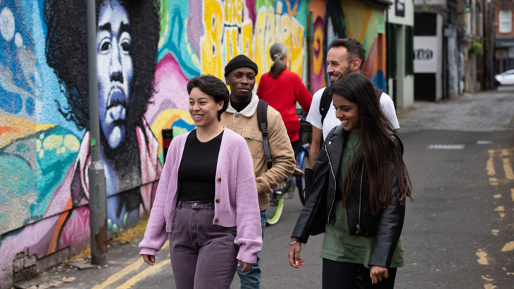 A group of young people walk through a vibrant city