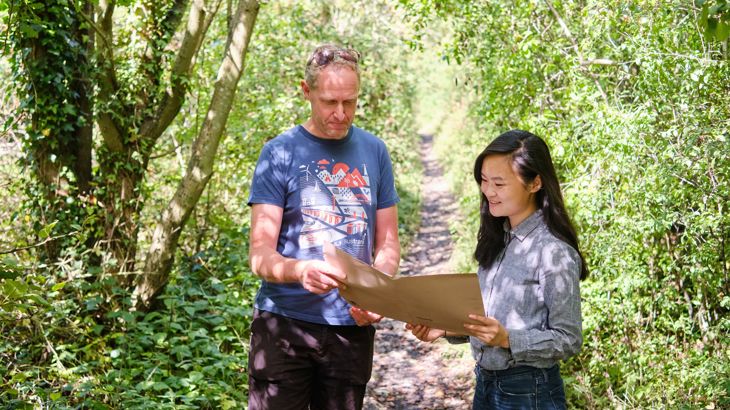 Carmen Szeto reviewing construction plans on site with Walk Wheel Cycle Trust Land Manager Martyn Brunt